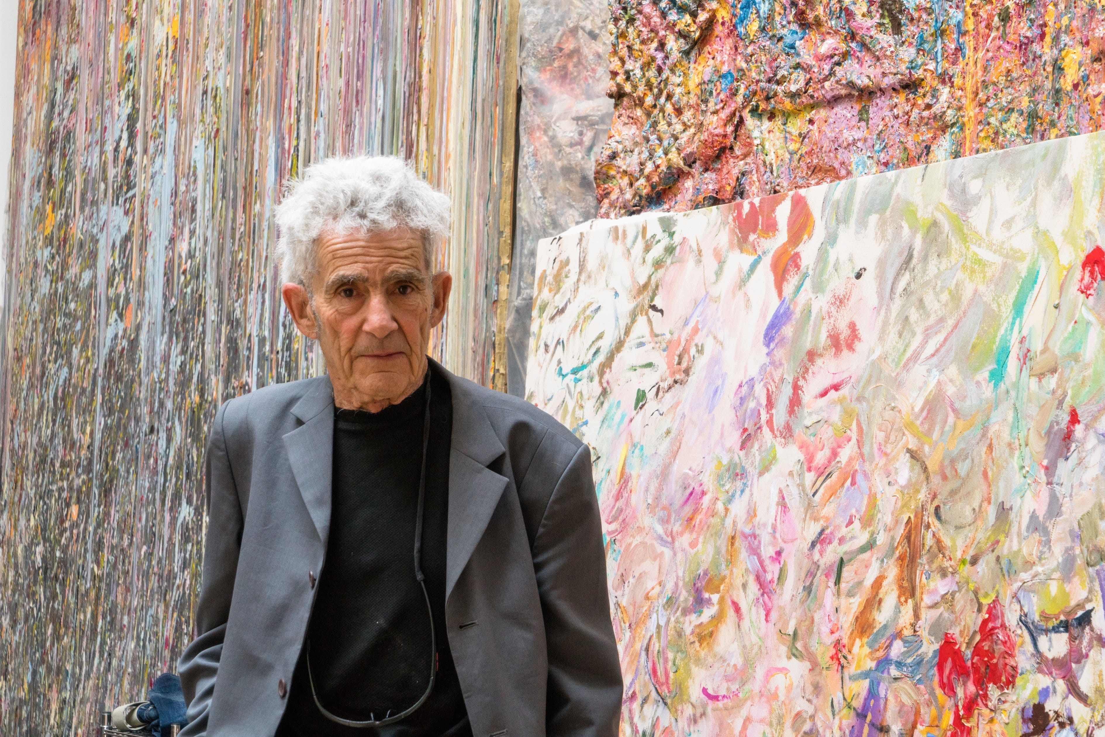 Portrait of Larry Poons in front of his artworks